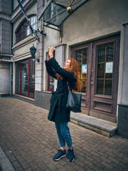 A girl traveler takes pictures on a mobile phone.