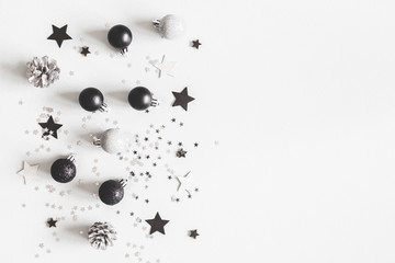 Christmas composition. Christmas black and silver decorations on pastel gray background. Flat lay, top view, copy space
