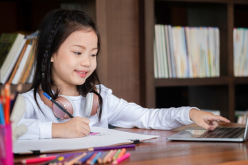 cute girl smiled and sitdown to drawing a book in the library, children concept, education concept