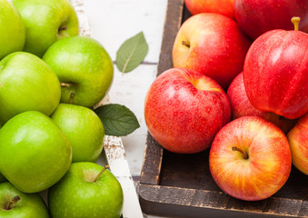 Fresh organic red and green apples in vintage box on wooden background. Top view