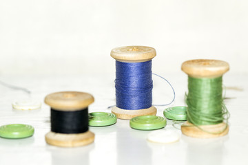 wooden coils with blue and green threads and lots of green butto