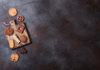 Oat and chocolate cookies selection on wooden board on stone kitchen table background. Space for text