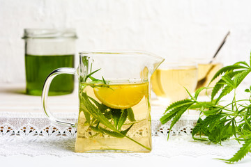 Cannabis tea with lemon and marijuana leaves