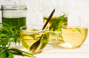 Cannabis tea with lemon and marijuana leaves