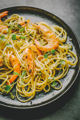 Spaghetti with pesto and prawns served on plate