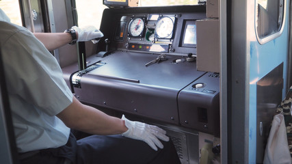 Train driver or crews is working on the train at control panel.