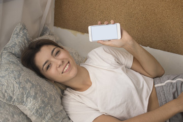 pretty young girl in bed with mobile phone