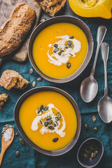 Autumn pumpkin creamy soup in bowls
