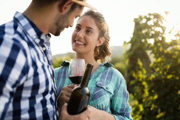 People sampling and tasting wines in vineyard