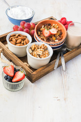 Paleo nut and fruit granola in a tray with fruits and berries, nut milk, coconut yogurt, copy space, selective focus