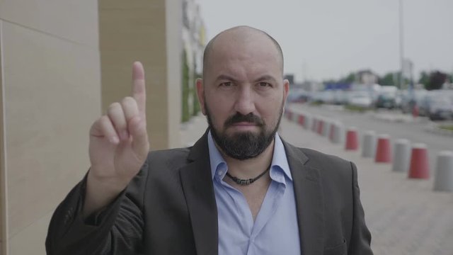 Business man waving index finger doing no gesture expressing denial outdoor