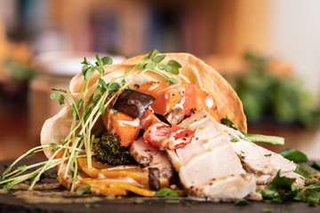 grilled chicken wrap with vegetables on plate 