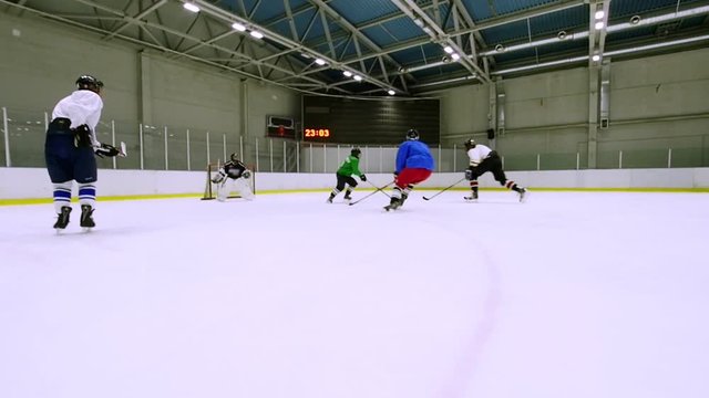 A team playing hockey on the ice during training. Slow motion.
