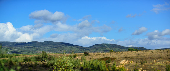 Nature landscape with mountains blue sky sunny day. Sunny fall day in nature. Natural background concept. Fields forest and mountains nature landscape