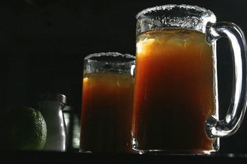 Two michelada jars which are a Mexican beverage made with beer, lime juice, and assorted willows,...