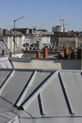 The roofs of Paris and its chimneys under a clouds sky