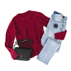 Red knitted sweater, blue jeans and small black cross body bag on white background. Overhead view of woman's casual day outfits. Trendy hipster look. Flat lay, top view.