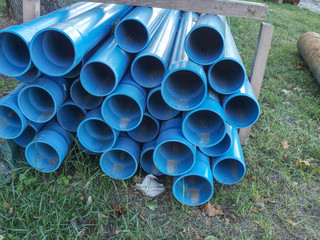 Bundles of blue plastic pipes for water transport. Pipe batch