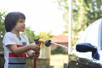 Little boy washing car
