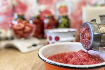 Twist tomatoes into tomato puree with an old hand grinder