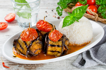 Meatballs wrapped in eggplant on a plate of rice