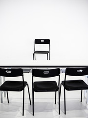 Black chairs with white table on white background. Interview place concept