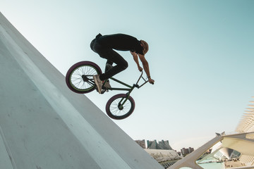 Young man with a bmx bike riding down the street