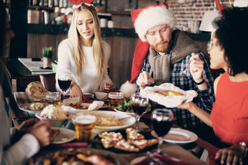 Friends having dinner at home at Christmas eve. Winter hoidays concept.