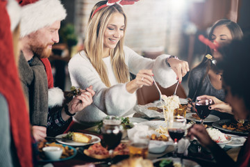 Friends having dinner at home at Christmas eve. Winter hoidays concept.