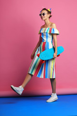 Fashion cool girl posing with skateboard.