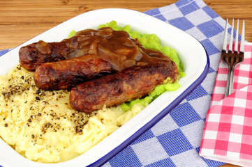 Sausages and mashed potato meal with mushy peas and onion gravy