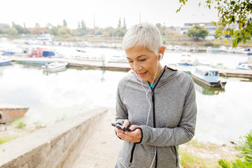 Senior Woman Relax Listening Music With Smartphone After Running