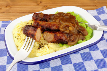 Sausages and mashed potato meal with mushy peas and onion gravy