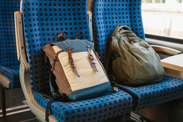Tourist concept. Two backpacks on the seats in the train.