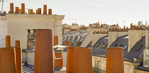 The roofs of Paris and its chimneys under a clouds sky
