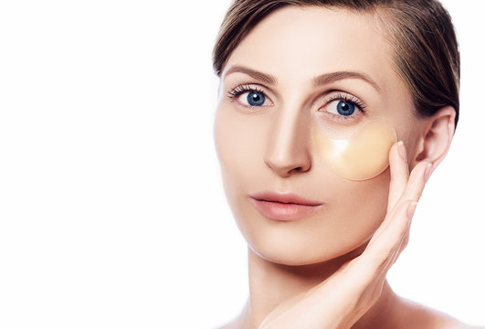 Face of beautiful woman with fresh daily make-up applying lift eye patches. Patches moisturizing and refreshing the skin under the eyes