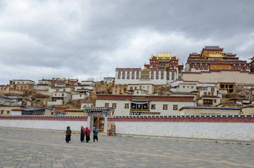 People walk outside Songzanlin Lama Tibetan Temple