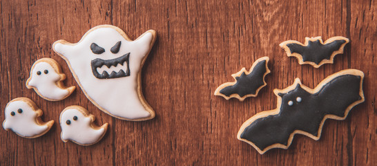 Fresh delicious homemade decorated halloween cookies sweets on dark wooden background, concept of halloween party, copy space(text space), top view, blank for text.