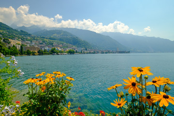 Naklejka na ściany i meble View to Montreux city from Geneva lake embankment at sunny summer day, flowers at foreground.