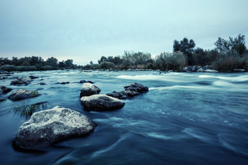 Stones in the water on shallow mountain river