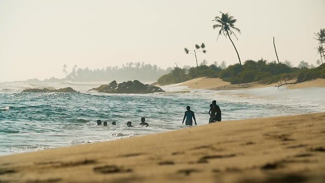 Silhouettes of teen boys bathing in the ocean