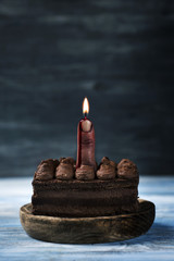 bloody middle finger with a lit wick on a cake