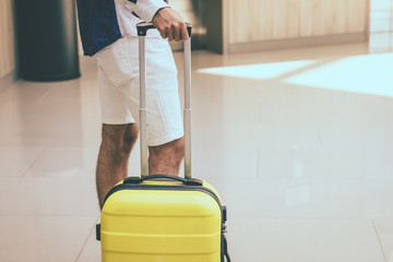 Man with suitcase waiting in a lobby.