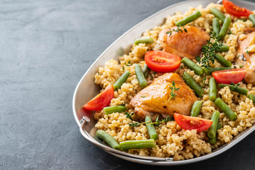 Grilled chicken thighs with bulgur, asparagus beans and tomatoes. Delicious lunch.