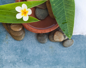 Top view of tropical flower and spa objects with stones for body and face massage treatment