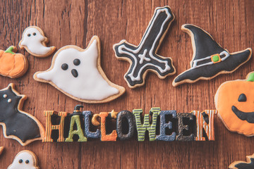 Fresh delicious homemade decorated halloween cookies sweets on dark wooden background, concept of halloween party, copy space(text space), top view, blank for text.