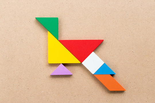 Color tangram puzzle in peacock or pheasant shape on wood background