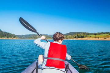 Woman kayaking on lake Lokve, young active girl on the Lokvarsko lake in Gorski kotar, Croatia,...