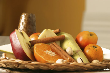 Basket with orange, apple, sugar cane, tejocote, tangerine, cinnamon, pear, and piloncillo to...