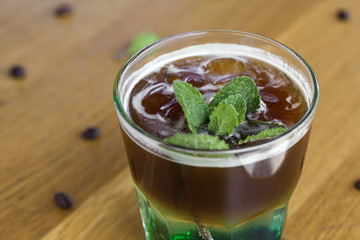 Cold coffee with mint leaves and ice cubes on the bar